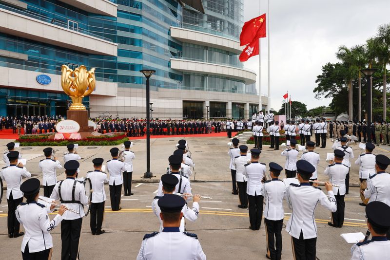 &copy; Reuters. Police officers raise Chinese and Hong Kong flags during a flag-raising ceremony marking the 24th anniversary of the former British colony's return to Chinese rule, on the 100th founding anniversary of the Communist Party of China, in Hong Kong, China Jul