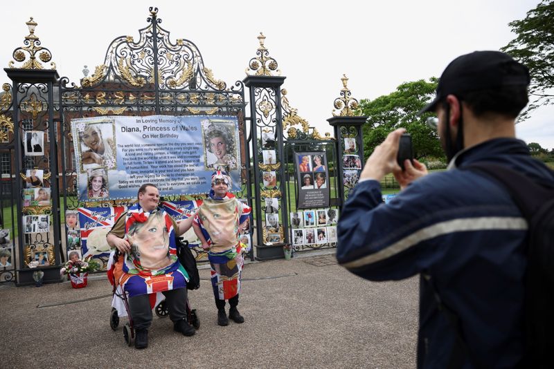 &copy; Reuters. التقاط صور لأناس أمام لافتة لتحية الأميرة ديانا خارج قصر كينزنجتون في العاصمة البريطانية لندن يوم الأربعاء. تصوير: هنري نيكولز - رويترز.