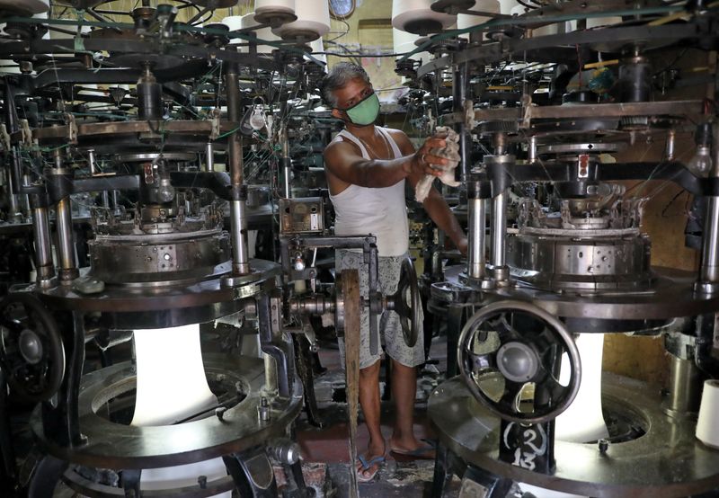 &copy; Reuters. A worker wearing a protective face mask cleans a machine inside an undergarment factory after it was re-opened after a weeks-long shutdown to slow the spread of coronavirus disease (COVID-19), in Kolkata, India, April 20, 2020. REUTERS/Rupak De Chowdhuri/