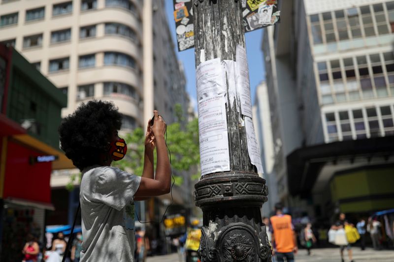 &copy; Reuters. FILE PHOTO: A woman photographs with her phone a job opportunity on job listings posted on a light pole in downtown Sao Paulo, Brazil, September 30, 2020. REUTERS/Amanda Perobelli