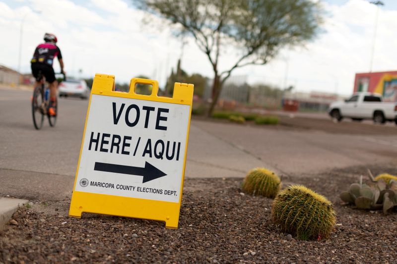 &copy; Reuters. FILE PHOTO: A sign points voters to a voting center for the Democratic primary in Sun City, Arizona, U.S., March 17, 2020.  REUTERS/Cheney Orr/File Photo