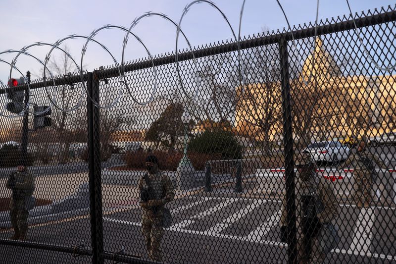 &copy; Reuters. FILE PHOTO: U.S. National Guardsmen stand duty behind the unscalable fence newly topped with razor wire surrounding the U.S. Capitol in the wake of the January 6th riot and ahead of the upcoming inauguration in Washington, U.S. January 14, 2021. REUTERS/J