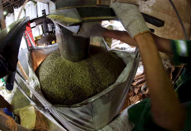 © Reuters. Trabalhador enchendo sacas de grãos de café para exportação em Santos, Brasil. 
10/12/2015 
REUTERS/Paulo Whitaker