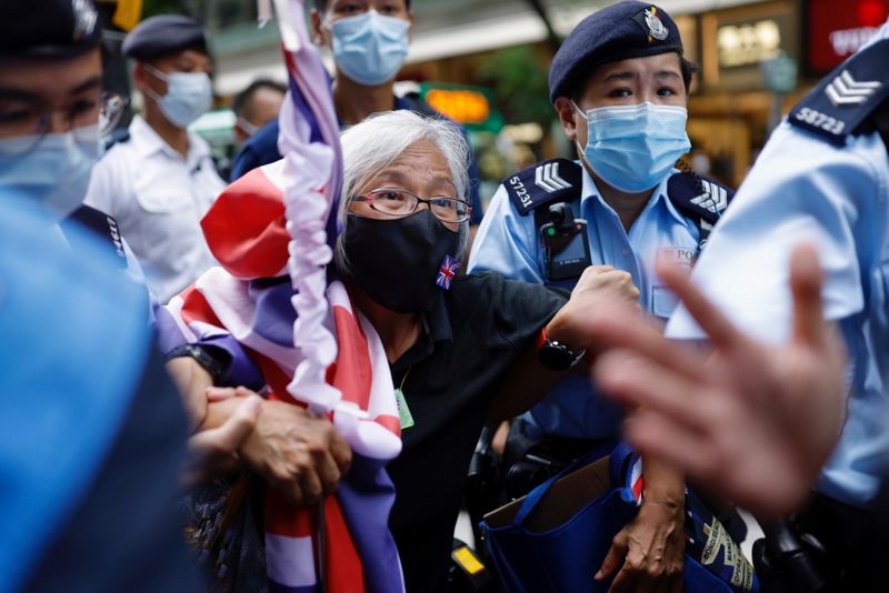 © Reuters. A pro-democracy protester with a Union flag mask is taken by police at Causeway Bay after police denied permission for a protest rally during the 24th anniversary of the former British colony’s return to Chinese rule, on the 100th founding anniversary of the Communist Party of China, in Hong Kong, China July 1, 2021. REUTERS/Tyrone Siu  