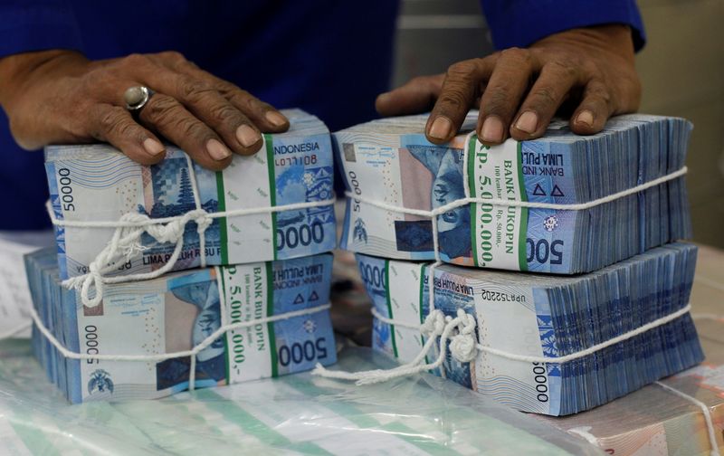 &copy; Reuters. FILE PHOTO: A worker prepares bundles of rupiah bank notes in Bank Mandiri in Jakarta July 9, 2013. REUTERS/Supri/File Photo