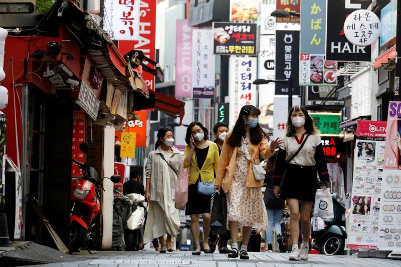 &copy; Reuters. FILE PHOTO: People wearing masks walk at Myeongdong shopping district amid social distancing measures to avoid the spread of the coronavirus disease (COVID-19), in Seoul, South Korea, May 28, 2020.   REUTERS/Kim Hong-Ji/File Photo