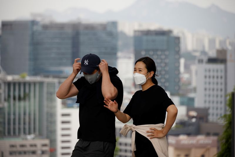 &copy; Reuters. FILE PHOTO:  couple wearing masks to avoid contracting the coronavirus disease (COVID-19) take a walk at a park in Seoul, South Korea, May 26, 2021. REUTERS/Kim Hong-Ji