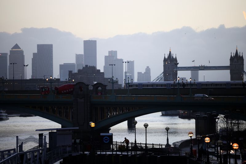 &copy; Reuters. FILE PHOTO: Canary Wharf can be seen in the distance as a person walks along a footbridge, amid the coronavirus disease (COVID-19) outbreak, in London, Britain, December 14, 2020. REUTERS/Henry Nicholls