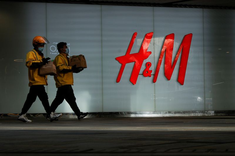 &copy; Reuters. FILE PHOTO: People walk past an H&M store in a shopping area in Beijing, China, March 28, 2021. REUTERS/Thomas Peter