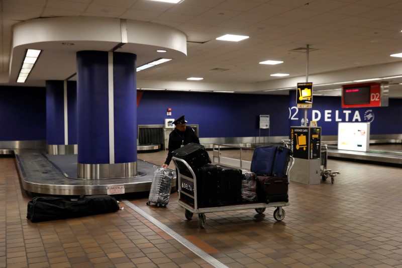 &copy; Reuters. FILE PHOTO: A baggage claim employee grabs bags from an empty baggage claim area in Delta terminal at LaGuardia Airport in New York, U.S., March 21, 2018. REUTERS/Shannon Stapleton
