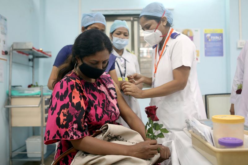 &copy; Reuters. Imagen de archivo de una trabajadora sanitaria sosteniendo una rosa mientras recibe la vacuna COVISHIELD de AstraZeneca, durante la campaña de vacunación contra el COVID-19, en un centro médico en Mumbai, India. 16 de enero, 2021. REUTERS/Francis Masca