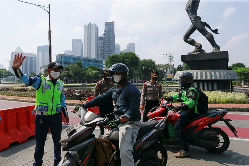 &copy; Reuters. Officials stop motorbikes while enforcing large-scale social restrictions to prevent the spread of coronavirus disease (COVID-19) in Jakarta, Indonesia, July 3, 2021. REUTERS/Ajeng Dinar Ulfiana