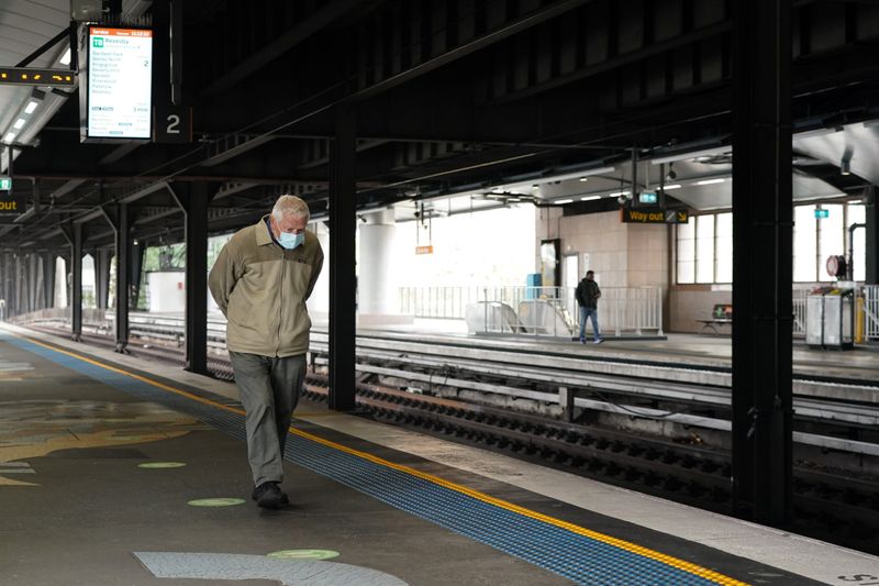 &copy; Reuters. FILE PHOTO: A lone passenger wearing a protective face mask walks along the deserted train platform at Circular Quay during a lockdown to curb the spread of a coronavirus disease (COVID-19) outbreak in Sydney, Australia, July 1, 2021. REUTERS/Loren Elliot