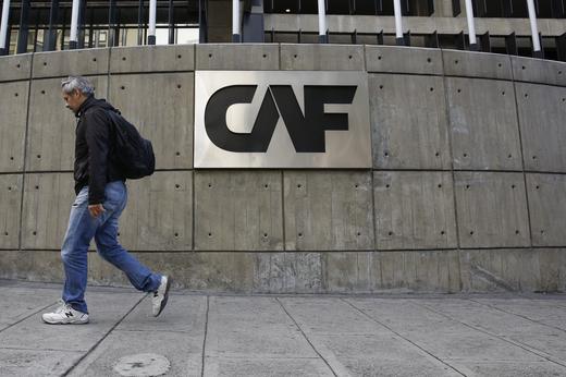 © Reuters. Foto de archivo. Un hombre pasa junto al logo corporativo del Banco de Desarrollo de América Latina (CAF) en su sede en Caracas, Venezuela, 22 de diciembre, 2015.  REUTERS/Carlos Garcia Rawlins