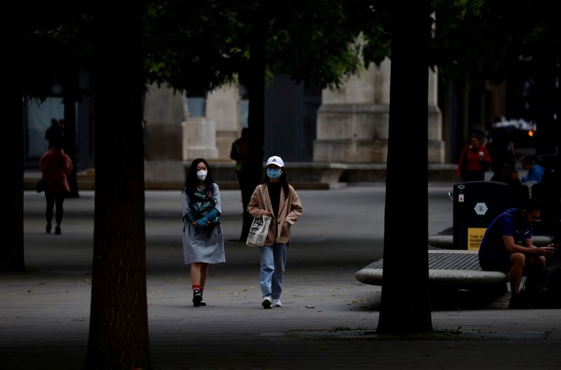 &copy; Reuters. FILE PHOTO: People wear protective masks as they walk through the city centre, amid the outbreak of the coronavirus disease (COVID-19) in Manchester, Britain, June 21, 2021. REUTERS/Phil Noble