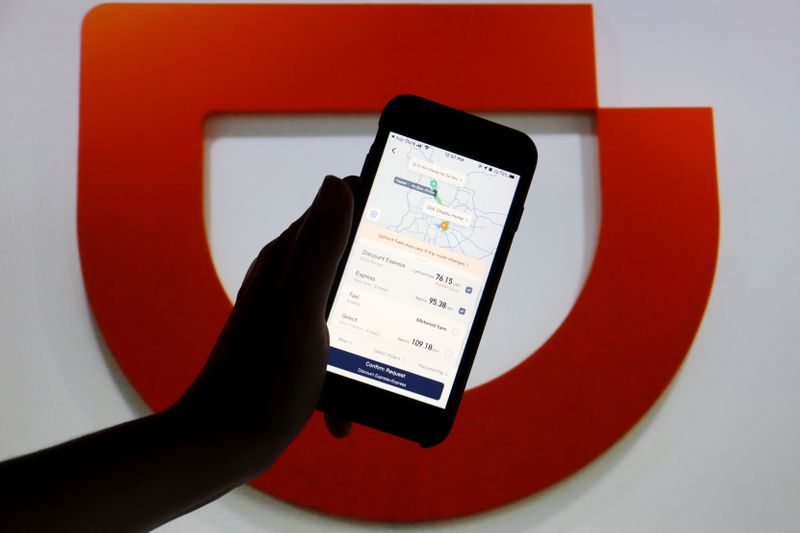 &copy; Reuters. FILE PHOTO: The app of Chinese ride-hailing giant Didi is seen on a mobile phone in front of the company logo displayed in this illustration picture taken July 1, 2021. REUTERS/Florence Lo/Illustration/File Photo