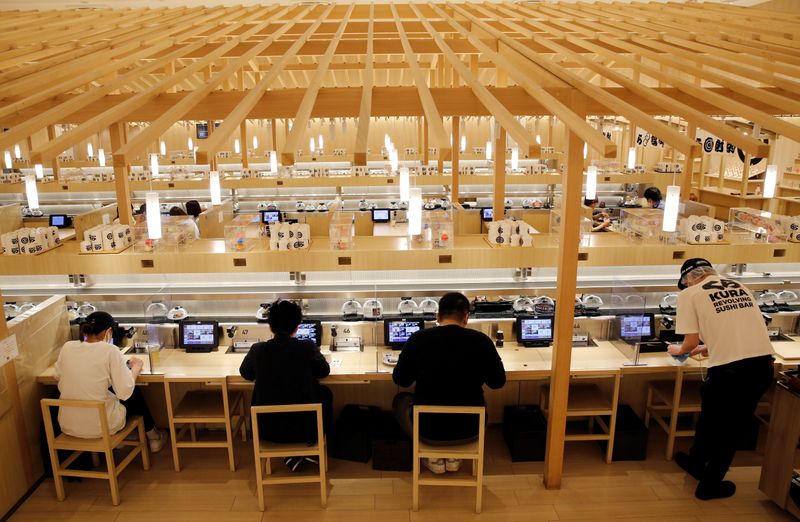 © Reuters. FILE PHOTO: Customers eat sushi off a conveyor belt at a Kura Sushi restaurant in Tokyo, Japan, June 3, 2021. REUTERS/Kim Kyung-Hoon