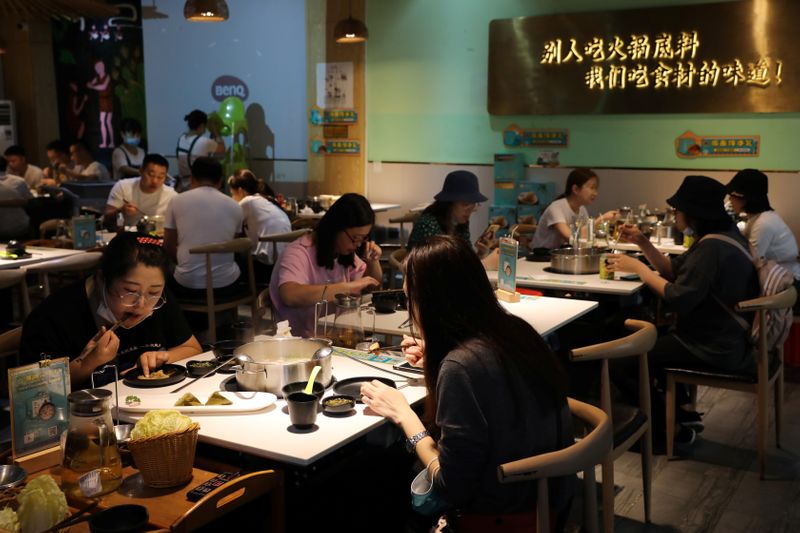 &copy; Reuters. FILE PHOTO: People dine at a hotpot restaurant in Sanya, Hainan province, China November 26, 2020. REUTERS/Tingshu Wang