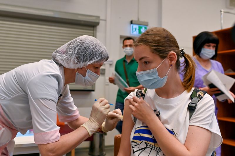 &copy; Reuters. Una donna riceve una dosa del vaccino Sputnik V (Gam-COVID-Vac) in un centro commerciale che funge da hub vaccinale a Omsk, Russia, 29 giugno 2021. REUTERS/Alexey Malgavko