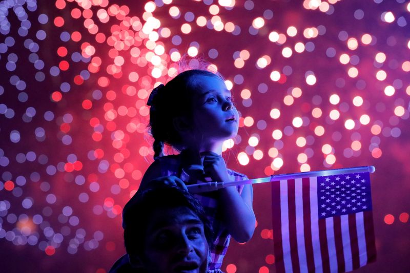 © Reuters. A child holds a U.S. flag as she watches the Macy's Fourth of July fireworks in New York City, New York, U.S., July 4, 2021. REUTERS/Andrew Kelly 