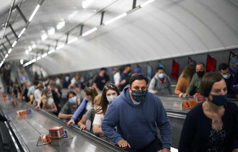 &copy; Reuters. FILE PHOTO: People, some wearing protective face masks, ride an escalator in Leicester Square underground station, amid the coronavirus disease (COVID-19) pandemic, in London, Britain, July 4, 2021. REUTERS/Henry Nicholls