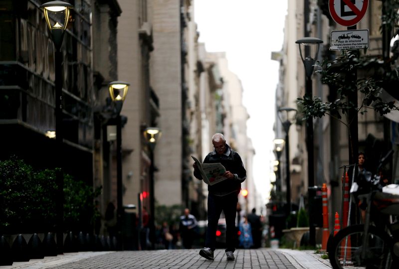 &copy; Reuters. FILE PHOTO: A man reads a newspaper as he walks in Buenos Aires' financial district, Argentina, April 18, 2016. REUTERS/Marcos Brindicci/File Photo