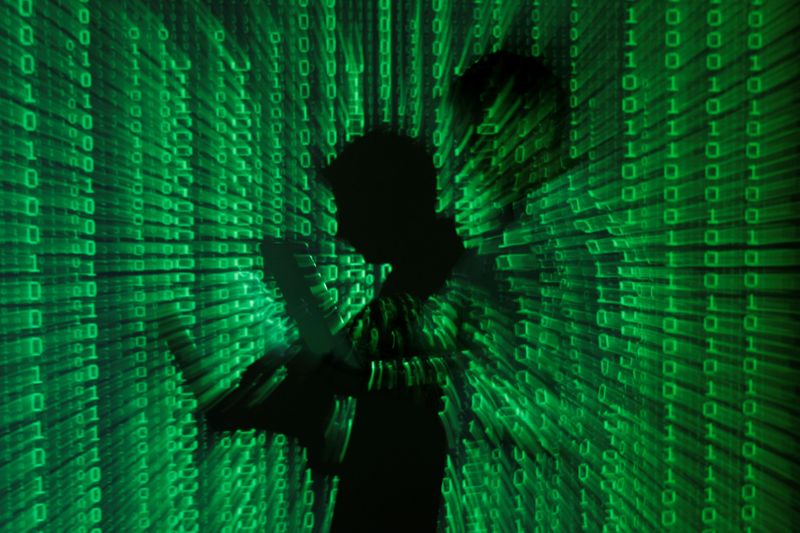&copy; Reuters. Projeção de códigos binários com homem no centro segurando um laptop
24/6/2013
REUTERS/Kacper Pempel