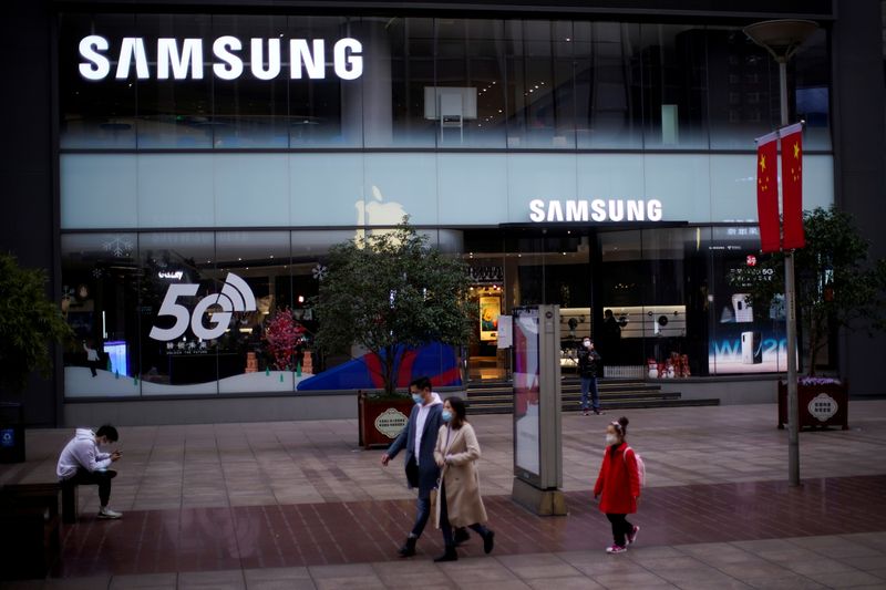 &copy; Reuters. FILE PHOTO: People wears masks in front of a Samsung store at a main shopping area as the country is hit by an outbreak of the new coronavirus in downtown Shanghai, China February 21, 2020. REUTERS/Aly Song/File Photo   