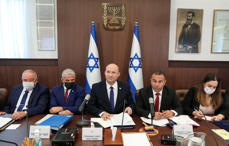 &copy; Reuters. FILE PHOTO: Israeli Prime Minister Naftali Bennett, sitting between Foreign Minister Yair Lapid and Government Secretary Shalom Shlomo, attends a weekly cabinet meeting at the prime minister's office in Jerusalem  July 4, 2021. Abir Sultan/Pool via REUTER