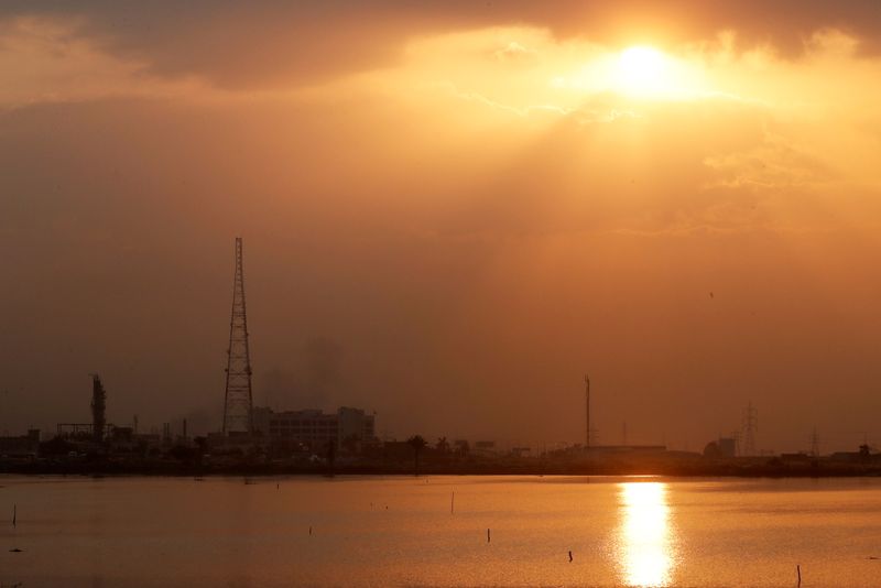 &copy; Reuters. FILE PHOTO: General view of factories of cement and petroleum by a salt lake at sunset near the port the Mediterranean city of Alexandria,  north of Cairo, Egypt December 6, 2020. REUTERS/Amr Abdallah Dalsh