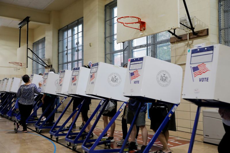 &copy; Reuters. FILE PHOTO: People stand in privacy booths as they fill ballots at PS 250 during the New York City primary mayoral election in Brooklyn, New York City, U.S., June 22, 2021. REUTERS/Andrew Kelly