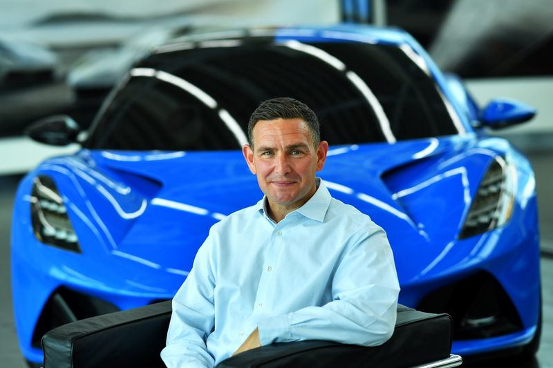 © Reuters. Managing Director of Lotus, Matt Windle sits beside an Emira car during an interview with Reuters at the car plant headquarters in Hethel, Britain June 23, 2021.   REUTERS/Dylan Martinez