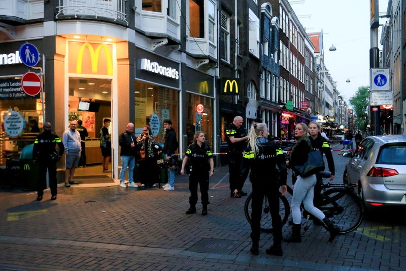 &copy; Reuters. People look on as police officers secure the area where Dutch celebrity crime reporter Peter R. de Vries, known for his reporting on some of the most renowned criminals in the Netherlands, was reportedly shot and seriously injured, in Amsterdam, Netherlan