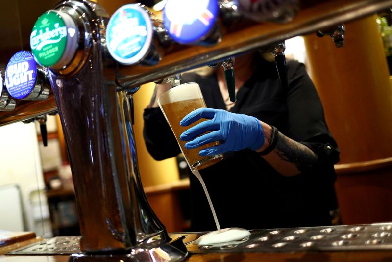 &copy; Reuters. FILE PHOTO: A worker serves a beer at The Holland Tringham Wetherspoons pub after it reopened following the outbreak of the coronavirus disease (COVID-19), in London, Britain July 4, 2020. REUTERS/Hannah McKay/File Photo
