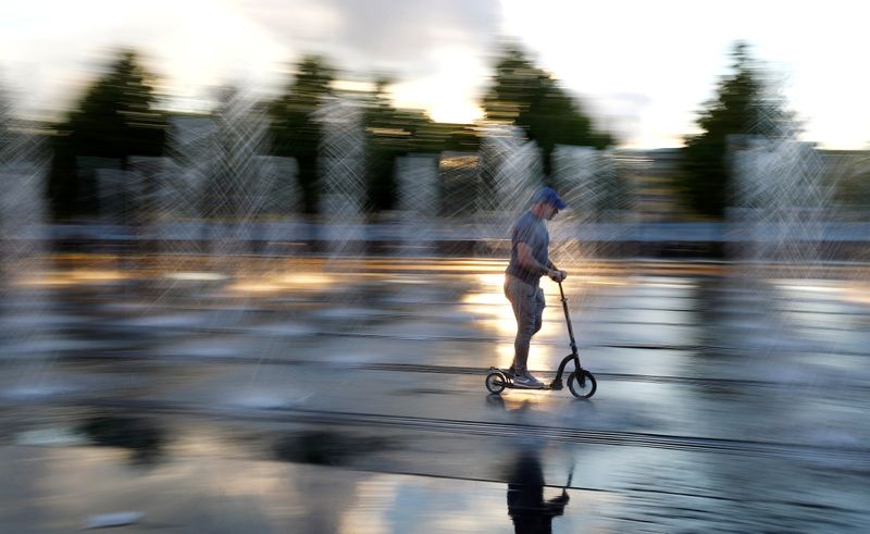 &copy; Reuters. A man rides his scooter through a fountain at Gorky Park in Moscow, Russia, July 9, 2018. REUTERS/Kai Pfaffenbach/Files