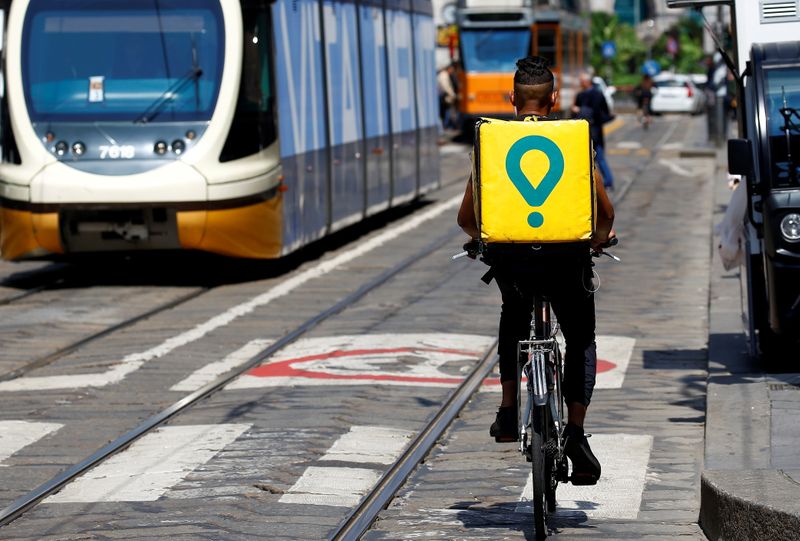 &copy; Reuters. FOTO DE ARCHIVO: Un repartidor de Glovo circula en bici por el centro de Milán