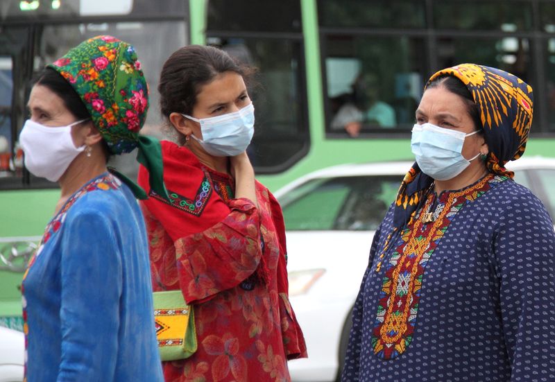 © Reuters. Women wearing protective face masks, used as a preventive measure against the spread of the coronavirus disease (COVID-19), are seen at a bus stop in Ashgabat, Turkmenistan July 13, 2020. Picture taken July 13, 2020. REUTERS/Vyacheslav Sarkisyan