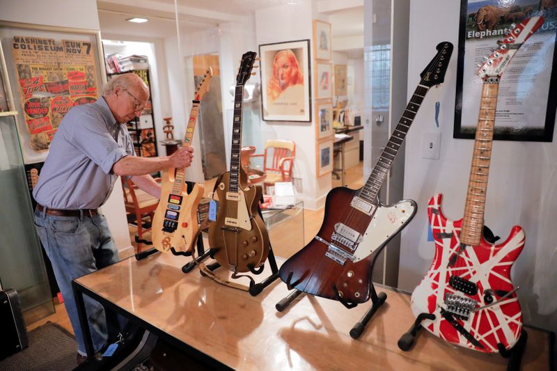 &copy; Reuters. Arlan Ettinger, presidente y fundador de la casa de subastas de Guernsey, coloca la guitarra "numbers" de Jason Becker en un soporte junto  antes de la subasta "Un siglo de música" en la ciudad de Nueva York, EEUU. 6 de julio de 2021. REUTERS/Andrew Kell