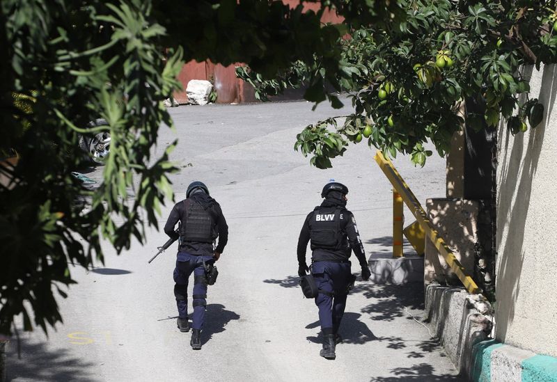 &copy; Reuters. ضباط شرطة يسيرون بالقرب من المنزل الخاص لرئيس هايتي جوفينيل مويس يوم الأربعاء. تصوير: رويترز.