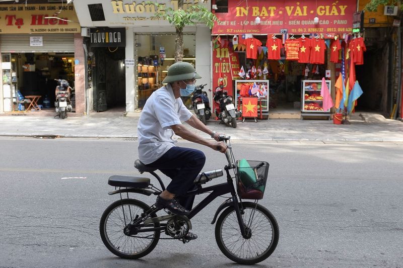 &copy; Reuters. FOTO DE ARCHIVO: Un hombre monta en bicicleta en una calle vacía en Han´pi, Vietnam, el 31 de mayo. REUTERS/Thanh Hue