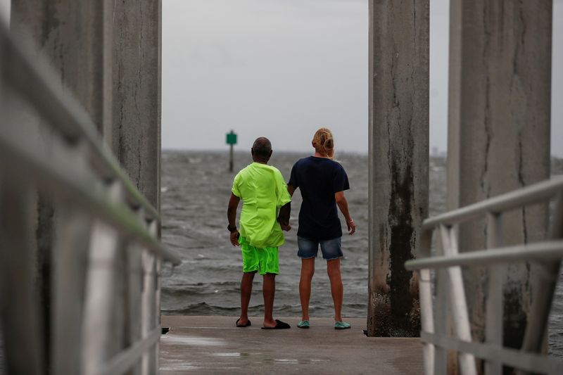 &copy; Reuters. Way Williams, 65, and his wife Jennifer, 60, stand holding hands at Bay Vista Park, as Elsa strengthened into a Category 1 hurricane hours before an expected landfall on Florida's northern Gulf Coast, in St. Petersburg, Florida, U.S.  July 6, 2021. REUTER