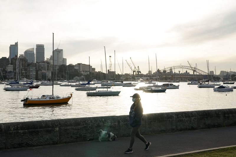 &copy; Reuters. A woman wearing a protective face mask walks along a waterfront path during a lockdown to curb the spread of a coronavirus disease (COVID-19) outbreak in Sydney, Australia, July 8, 2021.  REUTERS/Loren Elliott