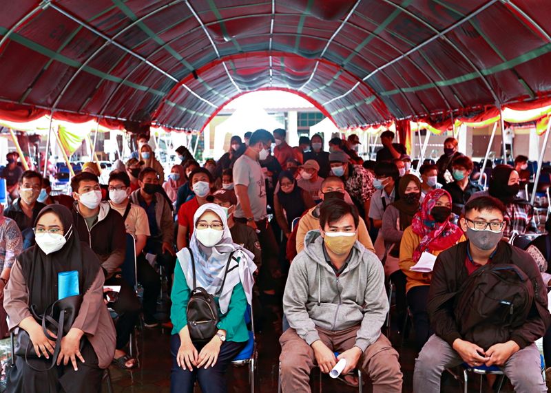 &copy; Reuters. FILE PHOTO: People wearing protective face masks sit before receiving a dose of the coronavirus disease (COVID-19) vaccine during the mass vaccination program at the Tangerang City Government Center, in Tangerang on the outskirts of Jakarta, Indonesia, Ju