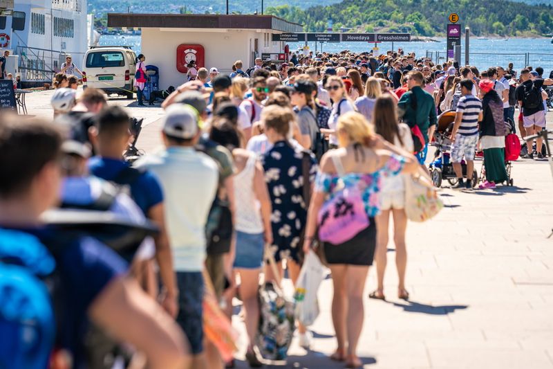 &copy; Reuters. FILE PHOTO: People queue on the City Hall quay to take boats to the islands in the Oslo Fjord as restrictions due to the coronavirus disease (COVID-19) outbreak limit the number of passengers on the ferries to 50, in Oslo, Norway May 31, 2020. NTB Scanpix