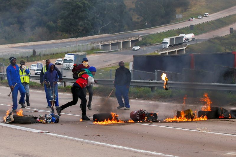 © Reuters. Supporters of former South African President Jacob Zuma block the freeway with burning tyres during a protest in Peacevale, South Africa, July 9, 2021. REUTERS/Rogan Ward