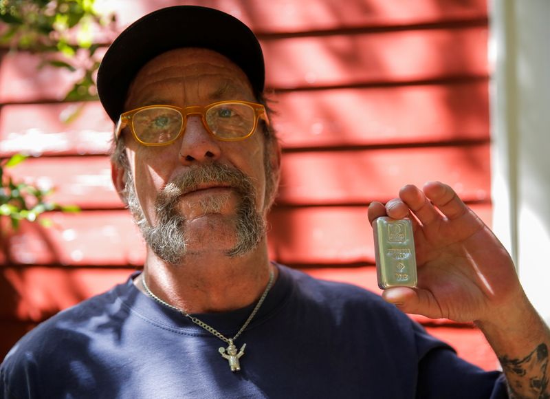 &copy; Reuters. Kerry Kraker, who is a part of the "Wall Street Silver" Reddit community and regularly invests in silver with his weekly savings, displays a 10-ounce silver bar while posing for a portrait at his home in Seattle, Washington, U.S., June 12, 2021. Picture t