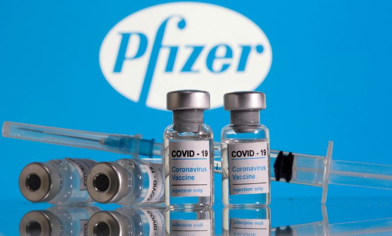 &copy; Reuters. Frascos de vacina contra a Covid-19 em frente ao logo da Pfizer 
09/02/2021
REUTERS/Dado Ruvic/Ilustração