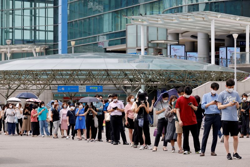 &copy; Reuters. FILE PHOTO: People wait in line for a coronavirus disease (COVID-19) test at a testing site, temporarily set up at a railway station in Seoul, South Korea, July 7, 2021.  REUTERS/ Heo Ran
