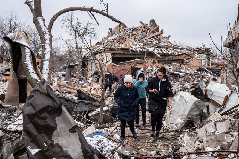 &copy; Reuters. Mulheres caminham em meio a destroços de prédio destruído por disparos de artilharia em Zhytomyr, na Ucrânia
02/03/2022 REUTERS/Viacheslav Ratynskyi