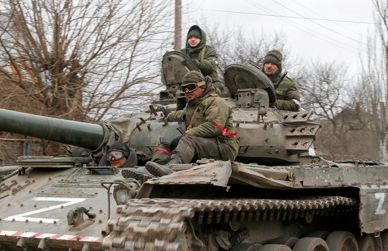 © Reuters. FILE PHOTO: Service members of pro-Russian troops in uniforms without insignia are seen atop of a tank with the letter 